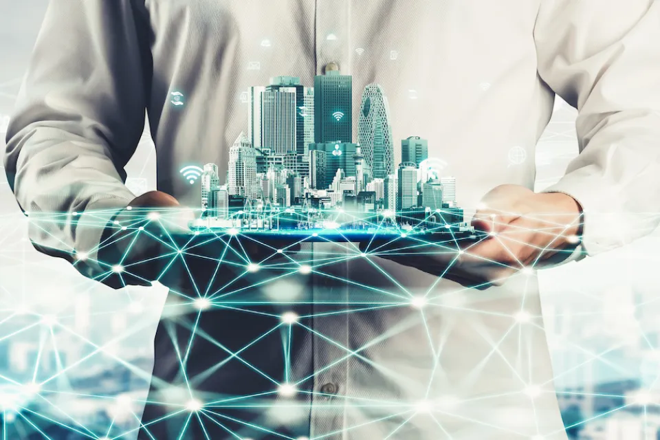 Digital drawing of person holding city skyline with wifi symbols and lines indicating smart cities or data.
